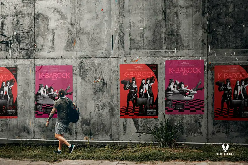 Piéton regardant un mur avec des affiches de théâtre